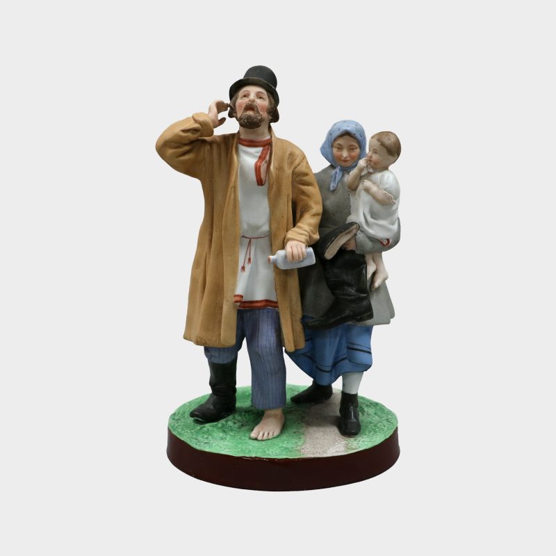 Gardner porcelain figure modeled as drunk man wearing one shoe, holding bottle and woman holding baby and man's other shoe