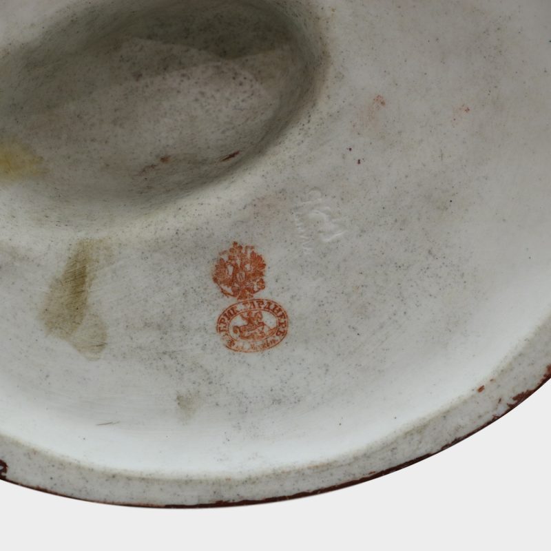 close-up of marks on Russian porcelain figure modeled as woman with kid trying to get her drunken husband off ground