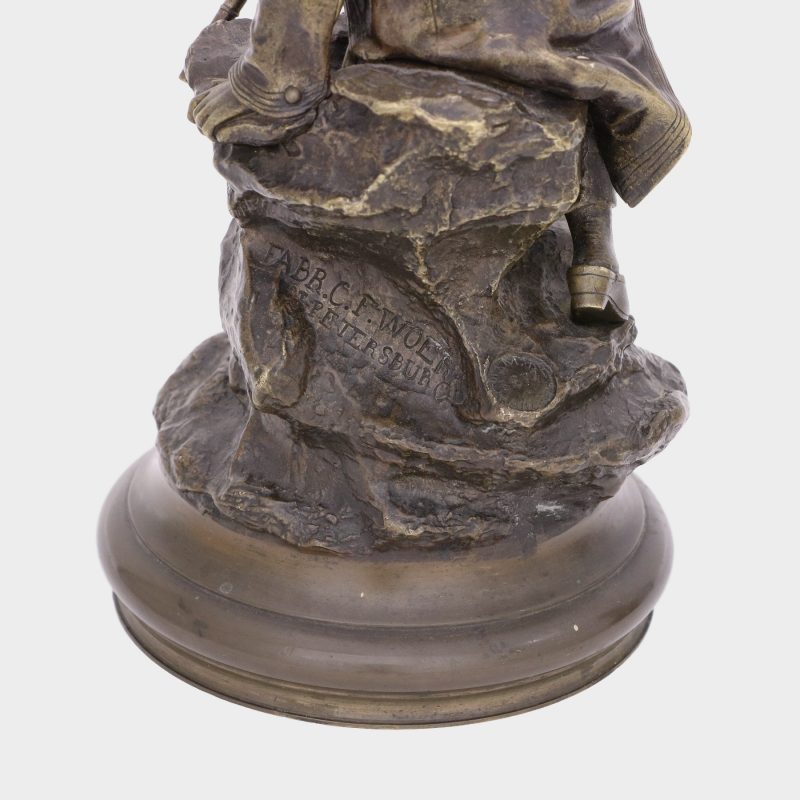 close-up of factory mark on Russian bronze figure by Vasili Grachev of eastern european female sentry holding pistol