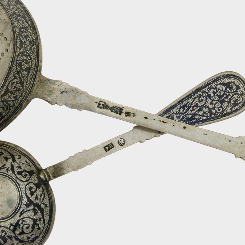 close-up of hallmarks on strainer and spoon from Russian silver tea set, 7 piece silver niello set with views of Moscow
