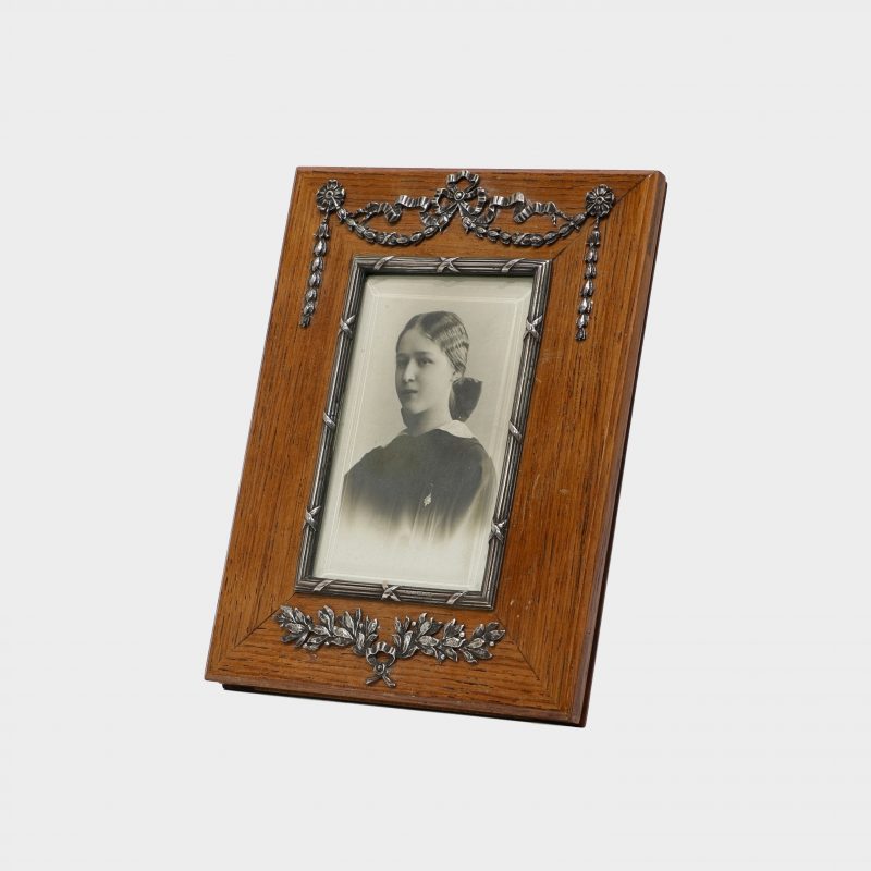 Faberge rectangular wood photo frame by Antti Nevalainen with silver swags and garlands at top and silver wrath at bottom