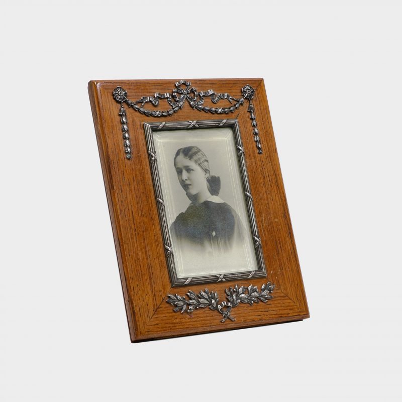 Faberge rectangular wood photo frame by Antti Nevalainen with silver swags and garlands at top and silver wrath at bottom