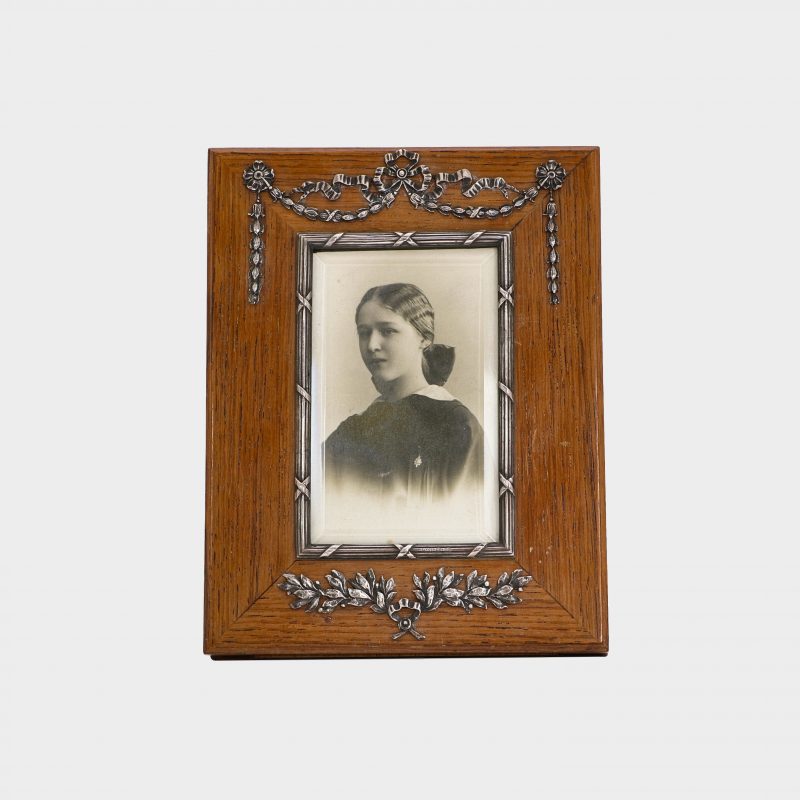 Faberge rectangular wood photo frame by Antti Nevalainen with silver swags and garlands at top and silver wrath at bottom
