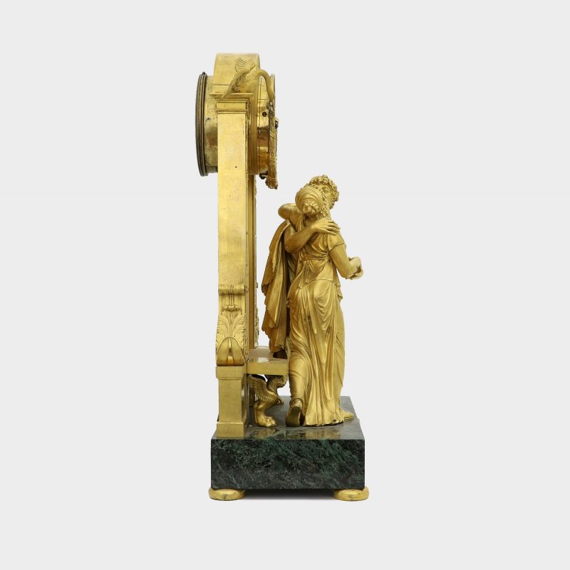 side view of Empire gilt-bronze clock on marble base modeled as couple embracing each other