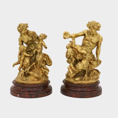 pair of Clodion bronze sculptures on round marble bases cast as satyr and satyress with baby satyrs and putti