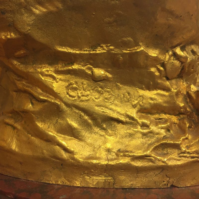 close-up of signature on gilded sculpture of satyress