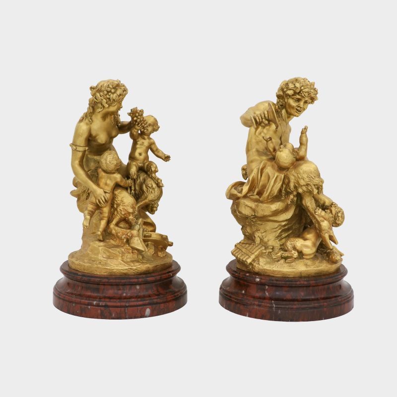 side view on pair of Clodion bronze sculptures on round marble bases cast as satyr and satyress with baby satyrs and putti