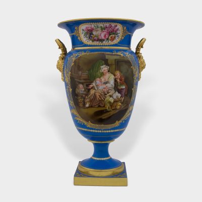 front of antique porcelain vase, probably Sevres, with painted genre scene against blue background and gilded handles