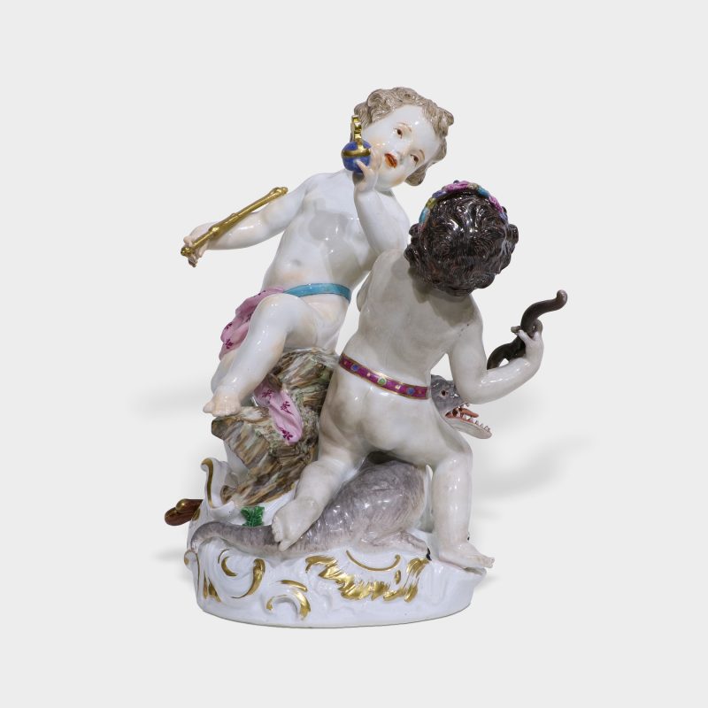 Meissen porcelain figurine modeled as two frolicking putti one holding bow and arrow and other holding orb and scepter