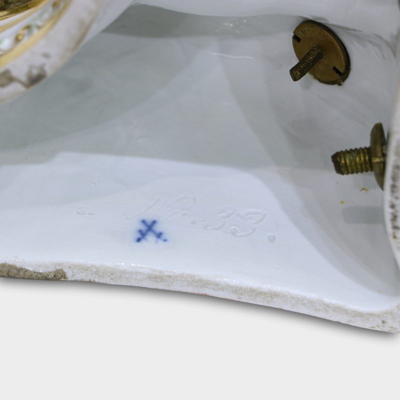 Close-up of blue crossed swords factory mark on base of porcelain sculpture